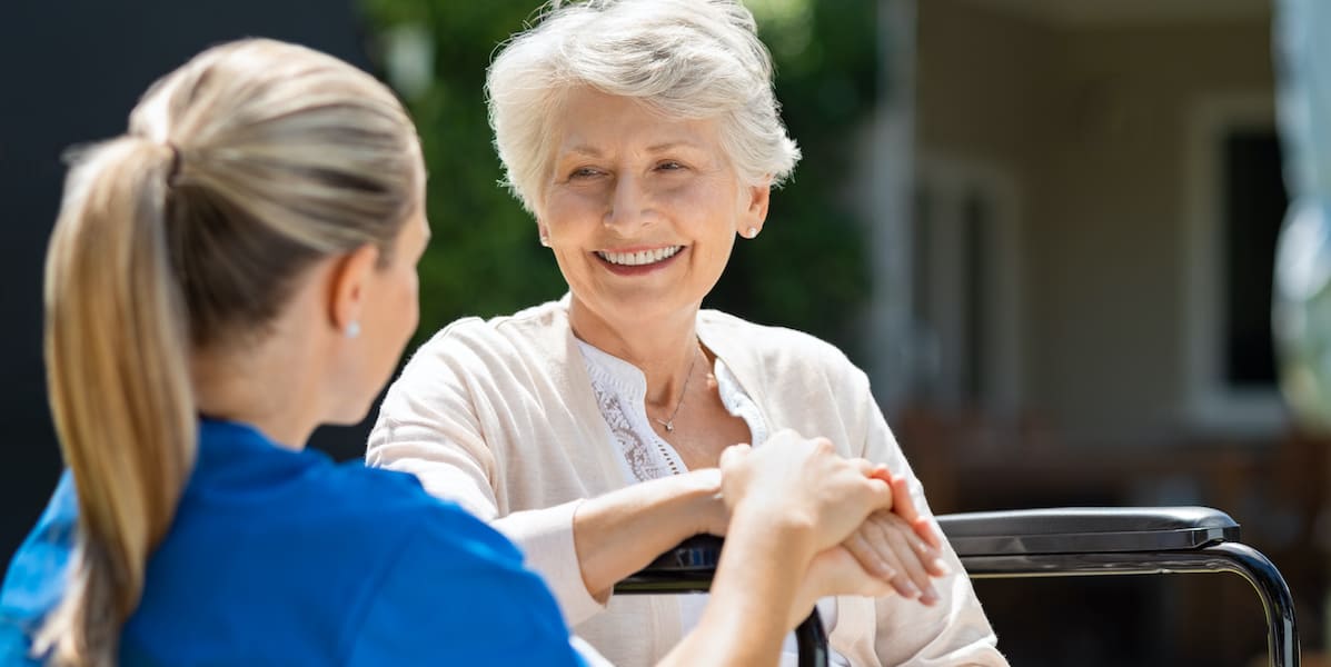 Nurse helping smiling resident at senior assisted living facility